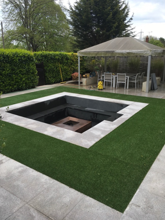Artificial lawn and sunken pond after